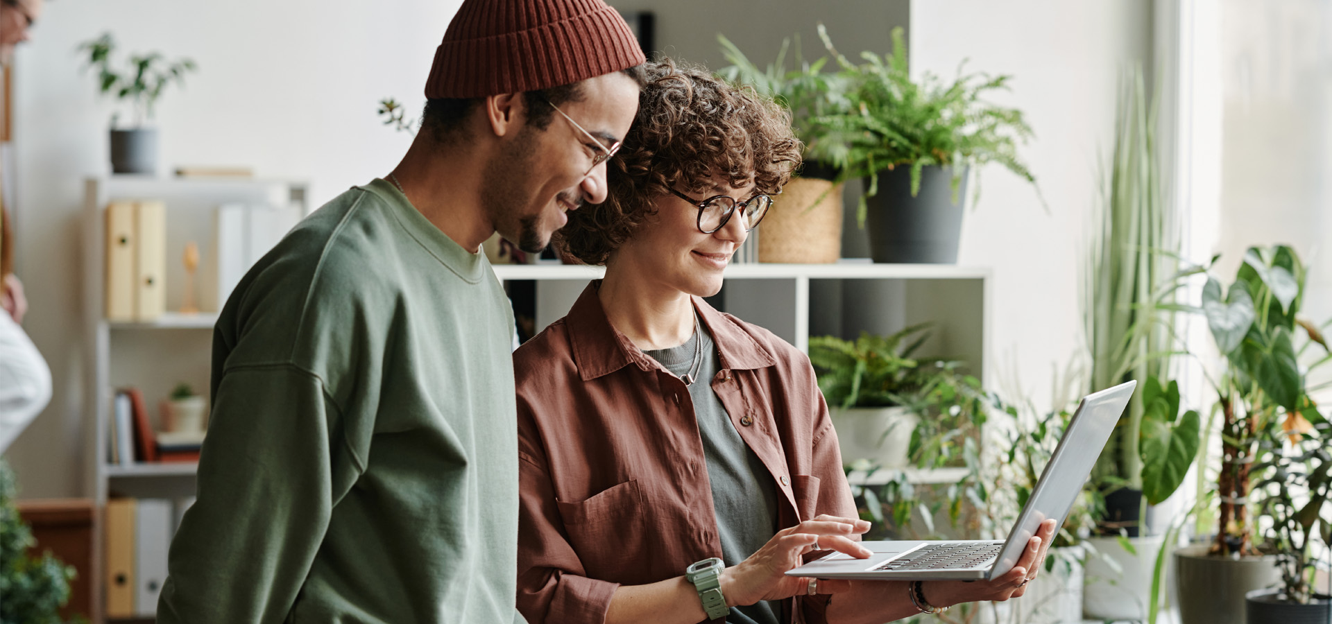 Zespół e-commerce pracujący nad personalizacją produktów print on demand na laptopie w nowoczesnym biurze